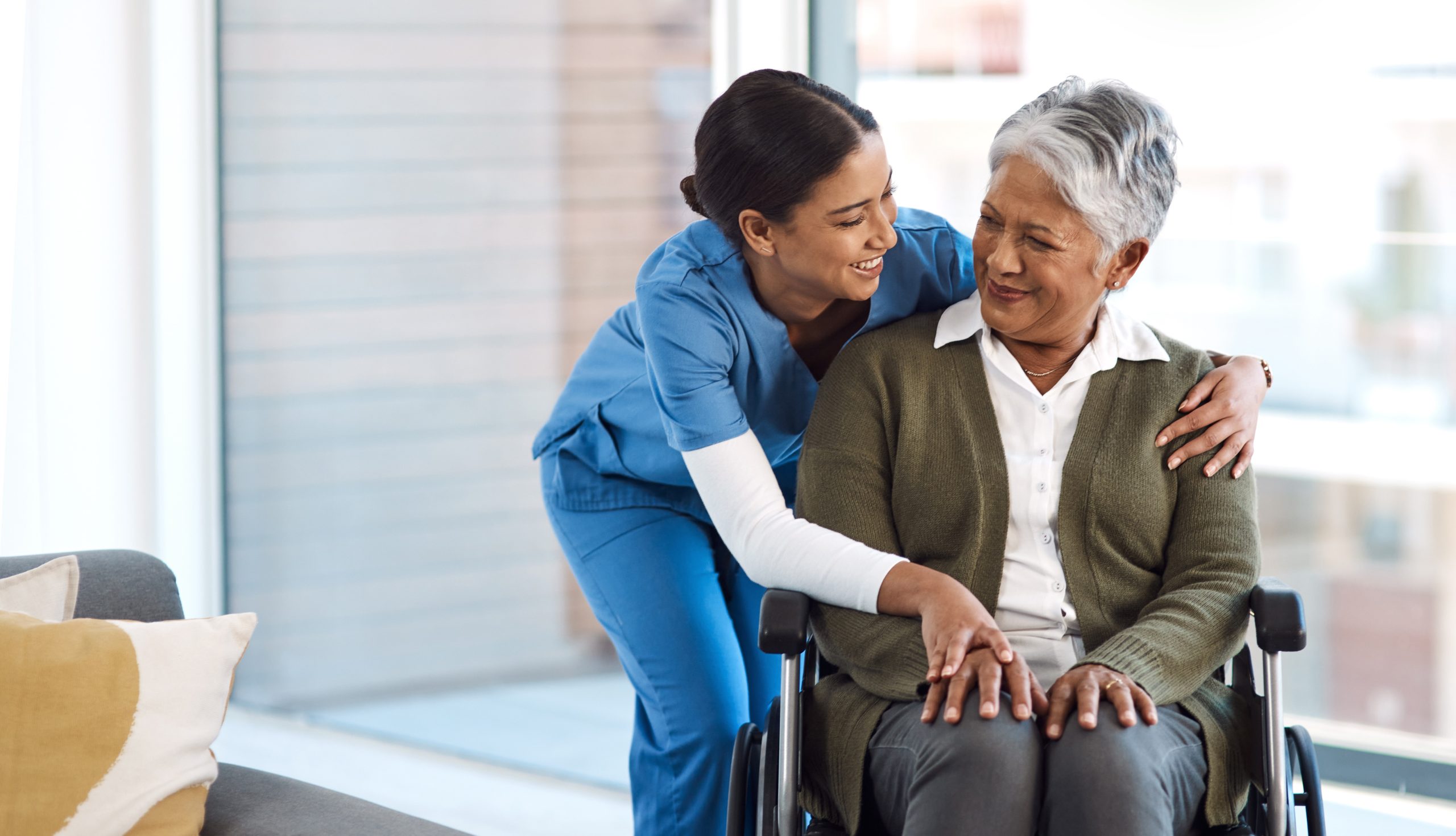 A disabled elderly woman communicating with a female nurse