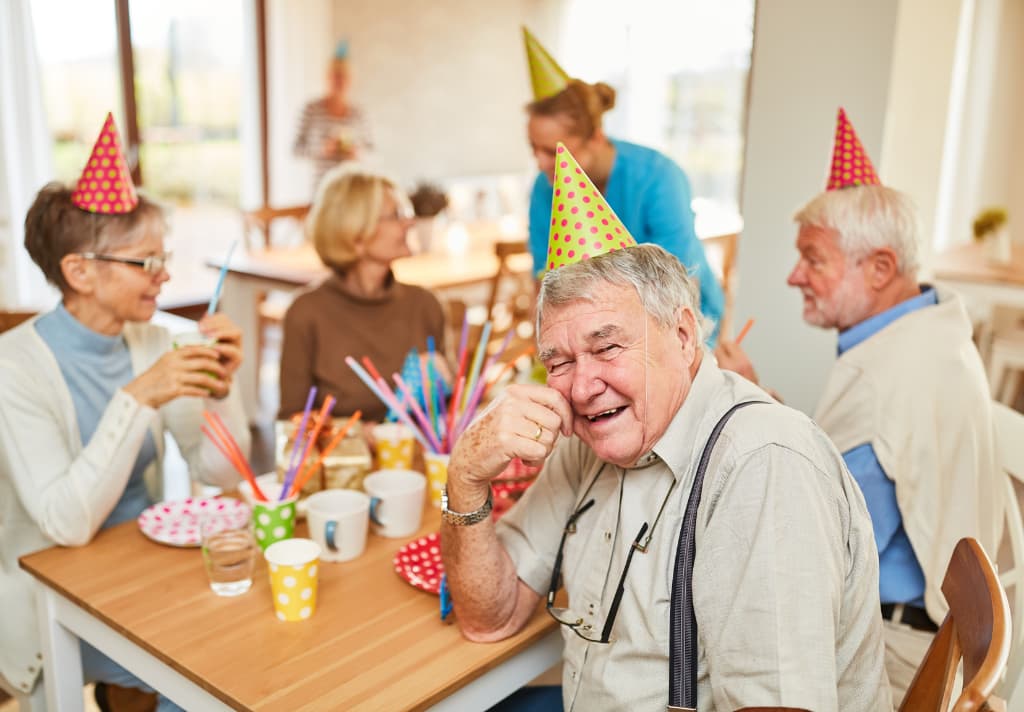 A joyful group of senior individuals celebrating a birthday together in a care home