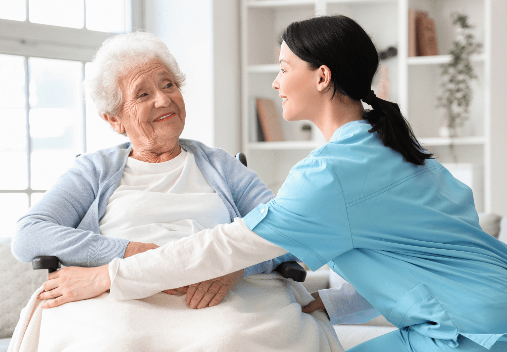 A nurse assists an elderly woman in a wheelchair, providing care and support in a compassionate manner