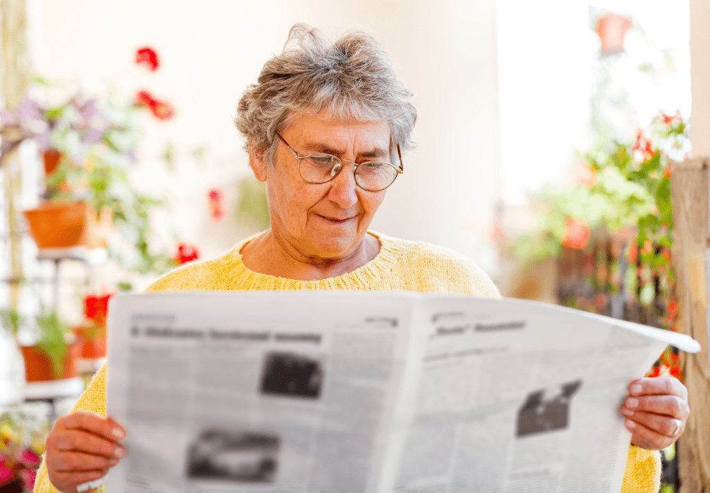 A woman focused on a newspaper, her expression reflecting curiosity and engagement with the news.
