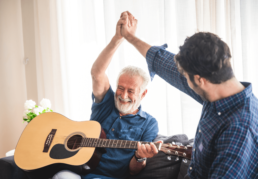 Two men playing guitar together, sharing a musical moment in a relaxed setting.