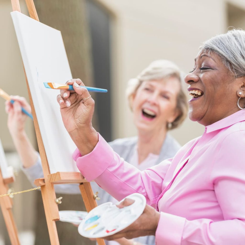 Two senior women painting
