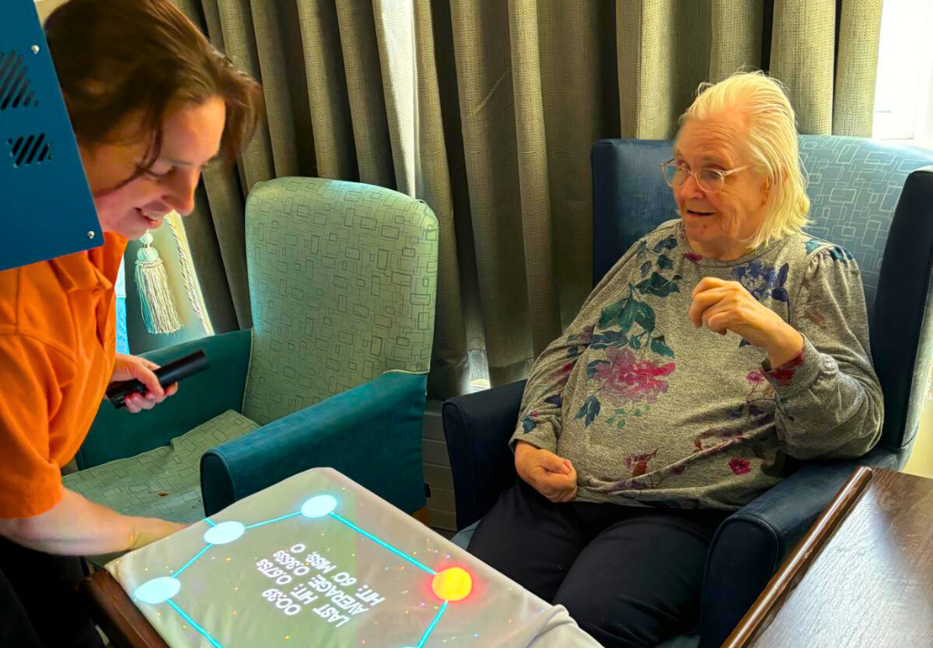 A woman and an older woman are engaged in a game, smiling and enjoying their time together.